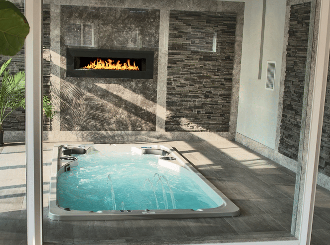 Indoor hot tub in front of a fireplace