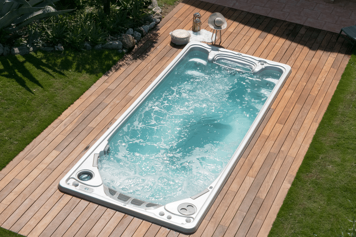 Backyard with a rectangular swim spa installed on a wooden platform